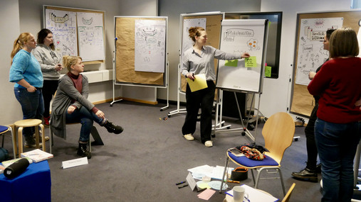 Blick in den Seminarraum: Die Teilnehmenden hören Lisa Dürer zu, sie erklärt etwas.