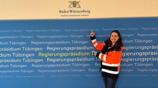 Foto zum Thema Public Management studieren: Zu sehen ist Julia, die das Studium absolviert hat und ihre Erfahrungen teilt. Sie eine trägt orangefarbige Sicherheitsjacke.