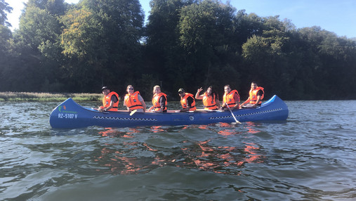 Das Foto zeigt eine Gruppe im Kanu auf dem Wasser.