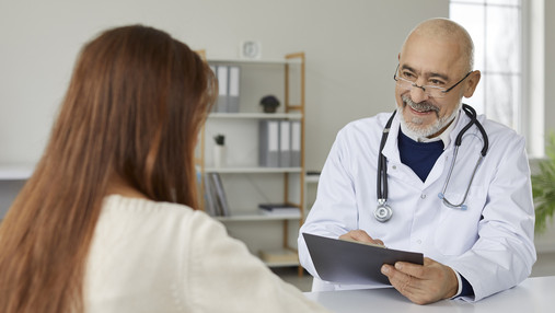 Foto zum Thema "der passende Weg zur Krankenversicherung": Zu sehe ist ein Arzt, der sich im Gespräch mit einer Patientin befindet.