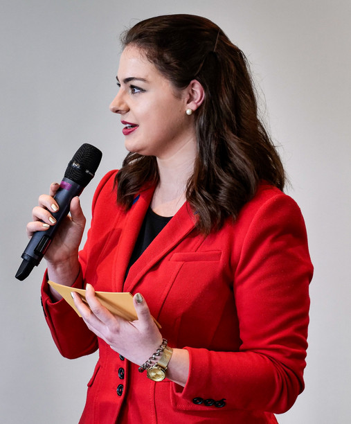 Das Foto zeigt Julia Mayer, Sprecherin der AG Europa der dbb jugend, mit einem Mikro und Moderationskarten in der Hand.
