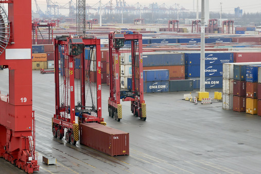 Foto zum Thema „Zoll Hamburger Hafen“: Zu sehen sind zwei Van-Carrier, die Container auf dem Hafengelände transportieren.