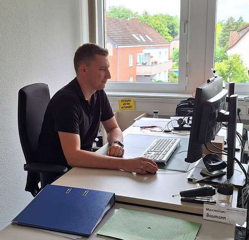 Foto zum Thema "Betriebsprüfer*in beim Finanzamt werden": Zu sehen ist Max am Schreibtisch in seinem Büro.