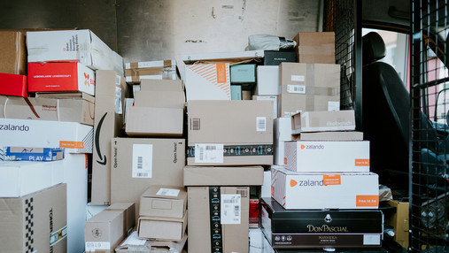 Foto zum Thema Probleme in der Paketzustellung: Zu sehen ist der Innenraum eines Zustellfahrzeugs, in dem sich sehr viele Pakete befinden.