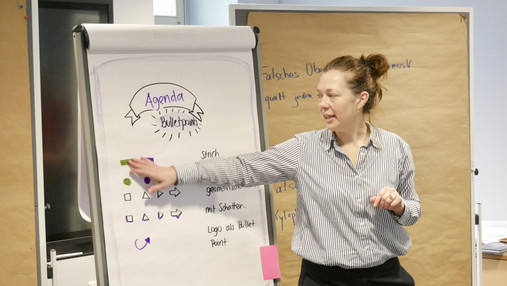 Das Foto zeigt Lisa Dürer, Geschäftsführerin der Akademie für Ehrenamtlichkeit. Sie erklärt etwas am Flipchart.