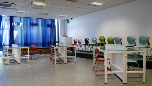 Foto zum Thema "JVA Hahnöfersand": Zu sehen ist der Besuchsraum. Drei Tische mit Glasplatten und Stühlen.