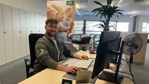 Foto zum Thema "Ausbildung zum Sozialversicherungsfachangestellten": Zu sehen ist Thies, der am Schreibtisch in seinem Büro sitzt.